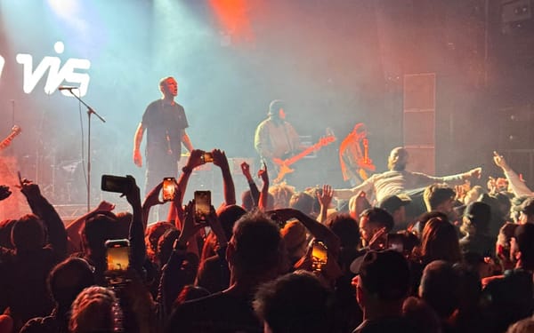 High Vis performing at Electric Brixton. An audience member crowd surfs while others film.